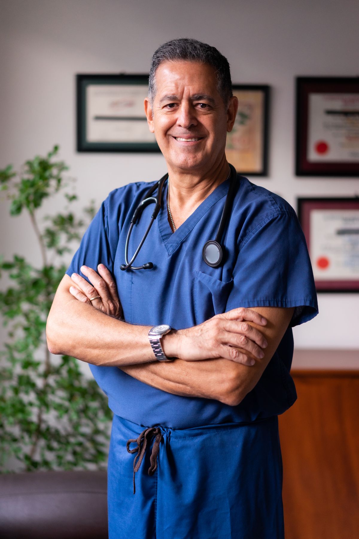 Portrait photo of a male veterinarian in blue scrubs